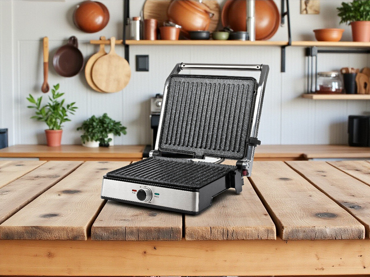 Grill elektryczny G3FERRARI Lavica Easy G10161, kuchnia, grillowanie, opiekanie, smażenie, grill stoi na blacie drewninanym w kuchni z otwartą pokrywą frontem prawo skos