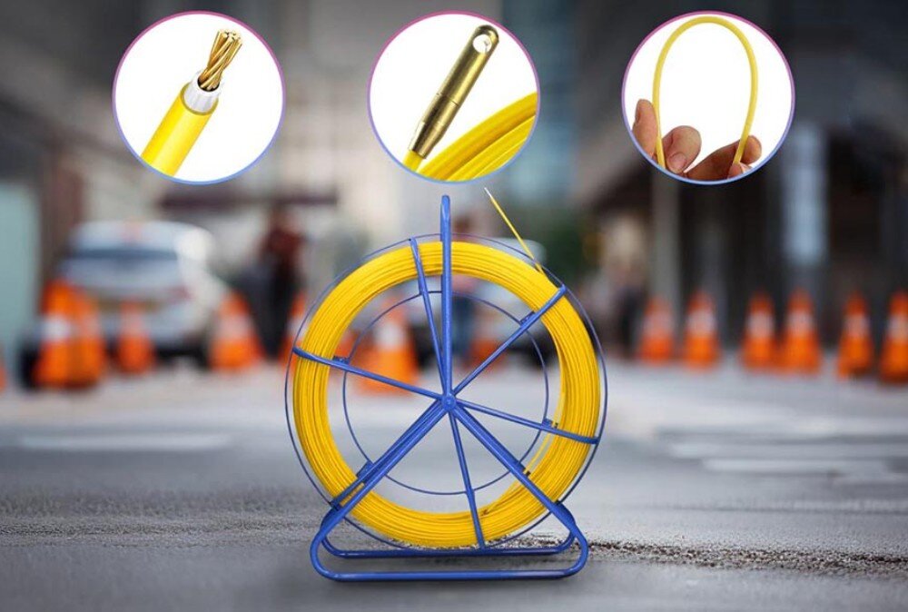 Pilot do przeciągania kabli EXTRALINK EX.31278 Niebieski stojak z żółtym przewodem ustawiony na ulicy z pachołkami drogowymi w tle, z trzema okrągłymi zbliżeniami pokazującymi szczegóły końcówki, przekroju i elastyczności przewodu
