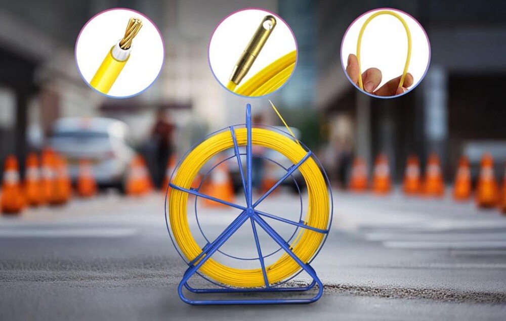 Pilot do przeciągania kabli EXTRALINK 30868 Niebieski stojak z żółtym przewodem ustawiony na ulicy z pachołkami drogowymi w tle, z trzema okrągłymi zbliżeniami pokazującymi szczegóły końcówki, przekroju i elastyczności przewodu
