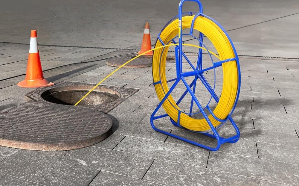 Pilot do przeciągania kabli EXTRALINK EX.30875 Niebieski stojak z żółtym przewodem ustawiony w pomieszczeniu gospodarczym