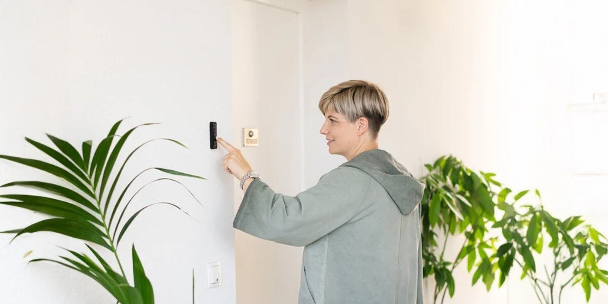 Klawiatura numeryczna NUKI Keypad 2, odciski, pin, zdalne, aplikacja, mężczyzna przyciska klawiaturę przy wejściu do domu