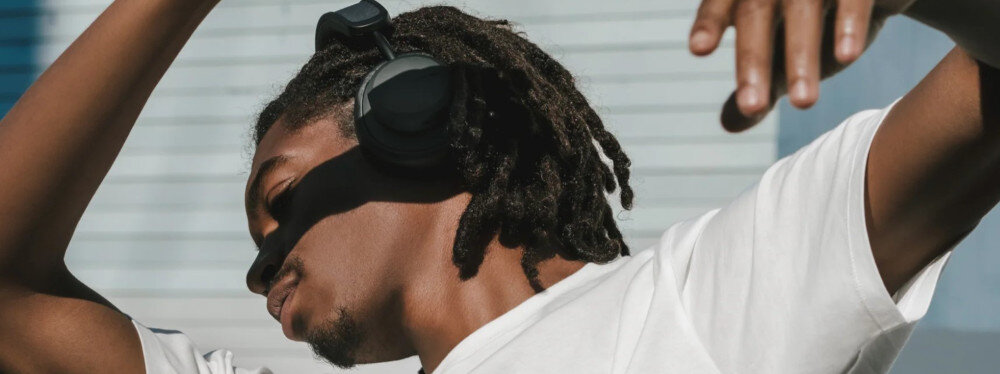 Słuchawki nauszne URBANISTA Los Angeles ANC, Bluetooth, detekcja nausznika, wygoda bez kabli, osoba założonymi słuchawkami nausznymi tańcząca w rytm muzyki