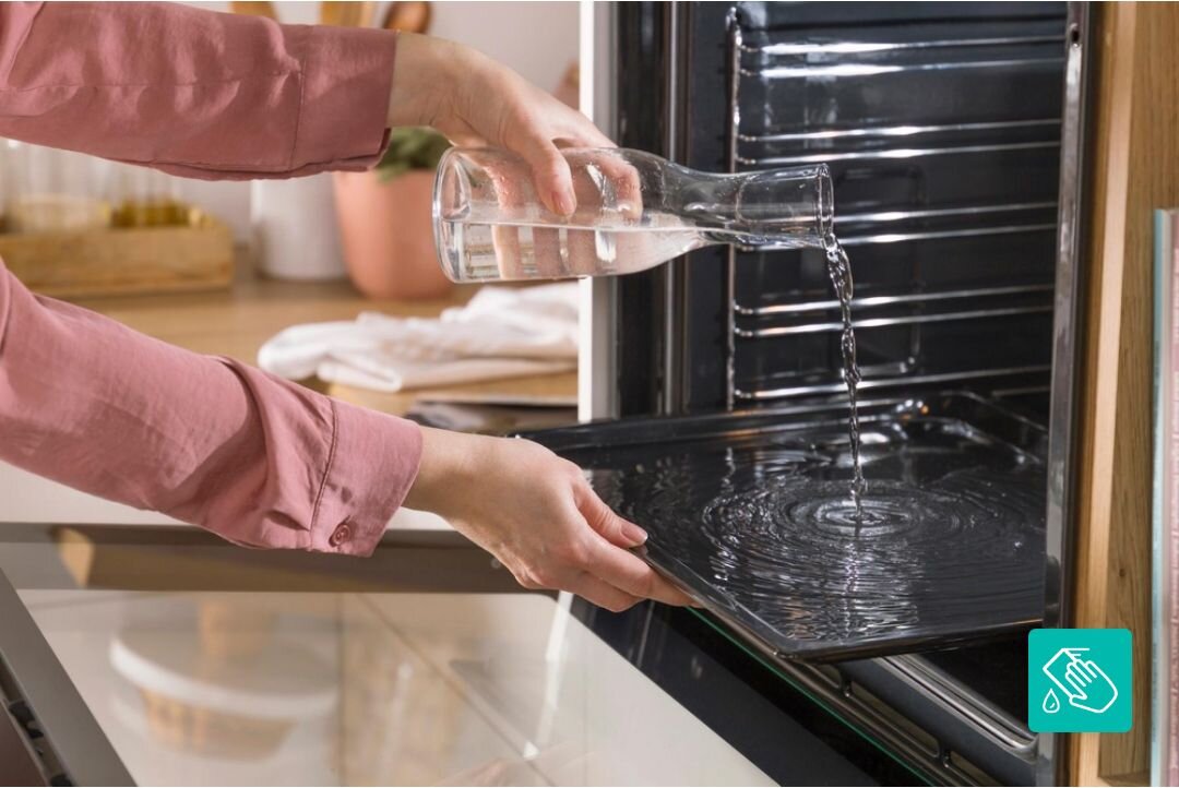PIEKARNIK GORENJE BOS67371CLB Nalewanie wody na dno piekarnika w celu użycia funkcji czyszczenia parowego. Zdjęcie podkreśla łatwą konserwację urządzenia