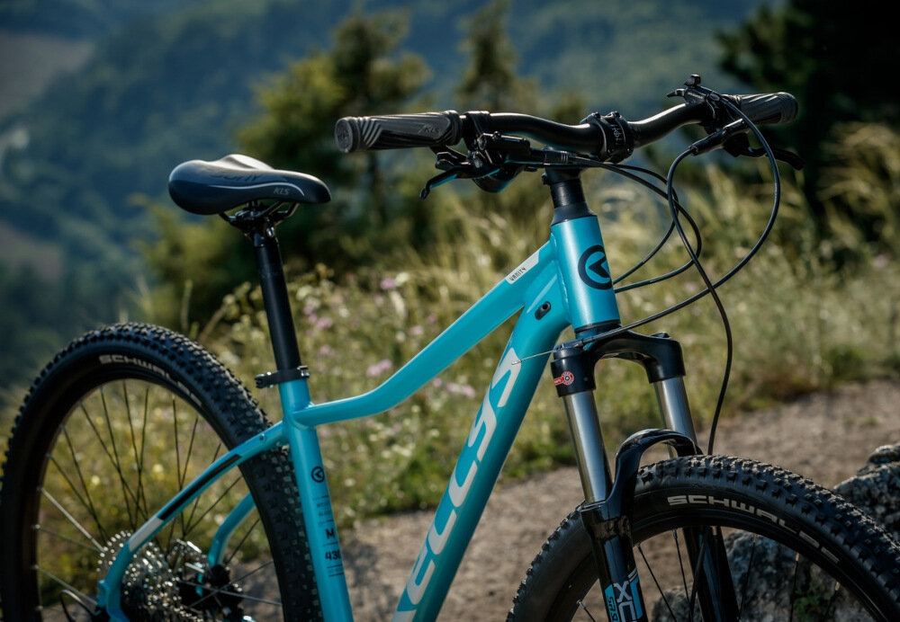 Rower górski MTB KELLYS Vanity 30 D16 29 cali damski Biały rower typu hardtail przedni amortyzator marki SR Suntour ułatwia najeżdżanie na przeszkody niweluje wstrząsy na kierownicy niska masa roweru duża sztywność