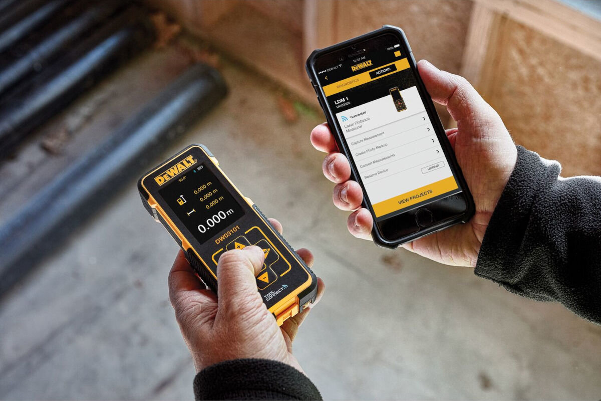 Dalmierz laserowy DEWALT DW03101-XJ 100m, bluetooth, moduł, aplikacja, wyniki, w dłoniach trzymany smartfon z aplikacją oraz dalmierz