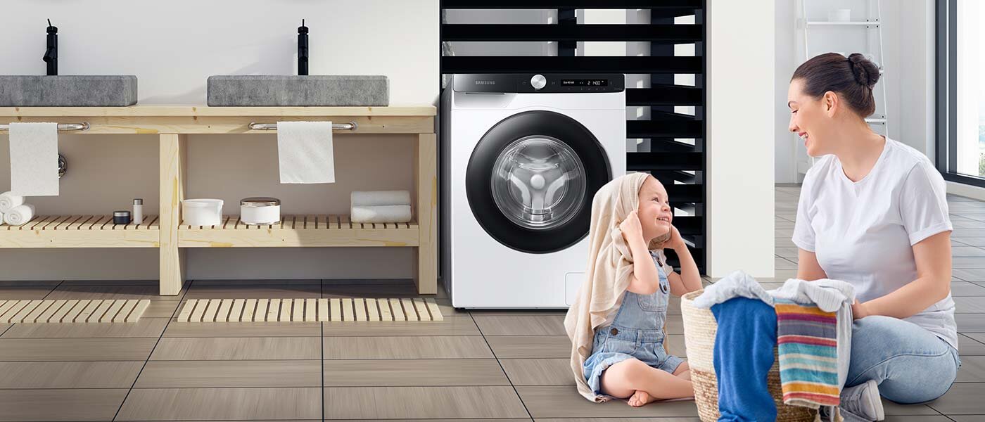 Mama z dzieckiem układają pranie, obok pralka Samsung 