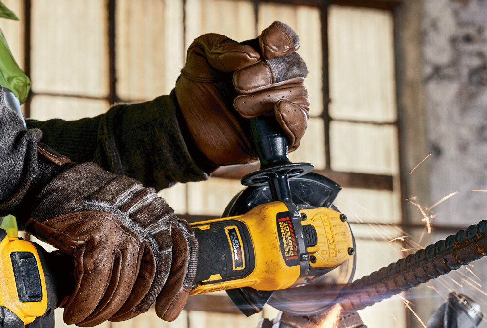 Szlifierka kątowa DEWALT DCG409H2T osoba używa szlifierki tnie metalową rurkę suwakowy włącznik z blokadą antypoślizgowa dwukomponentowa obudowa stabilny chwyt dwupozycyjne mocowanie uchwytu bocznego indywidualne dopasowanie do stylu pracy i dominującej ręki