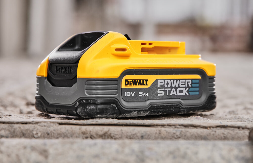 Szlifierka kątowa DEWALT DCG405H2T-QW akumulator ustawiony na chodniku zasilanie akumulatorem Li-Ion 18 V o pojemności 5.0 Ah z serii PowerStack długi czas pracy bez przerw na ładowanie technologia litowo-jonowa stabilne napięcie i długą żywotność akumulatorów w zestawie dwa akumulatory i ładowarka wielonapięciowa