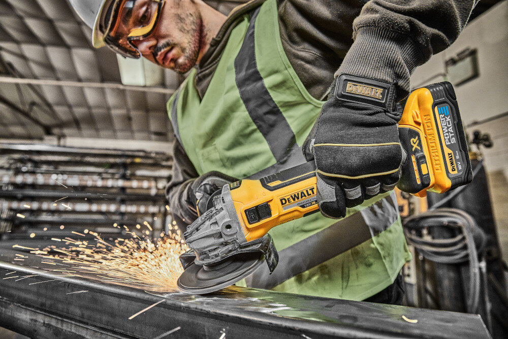 Szlifierka kątowa DEWALT DCG405H2T-QW osoba używa szlifierki szlifuje metalowy element beznarzędziowo ustawiana osłona tarczy ułatwia to pracę w zmiennych warunkach bezpieczeństwo sprawnie reagować na bieżące potrzeby przycisk blokady wrzeciona M14 szybka zmiana tarczy nie wymaga zastosowania narzędzi współpracuje z tarczą o średnicy 125 mm
