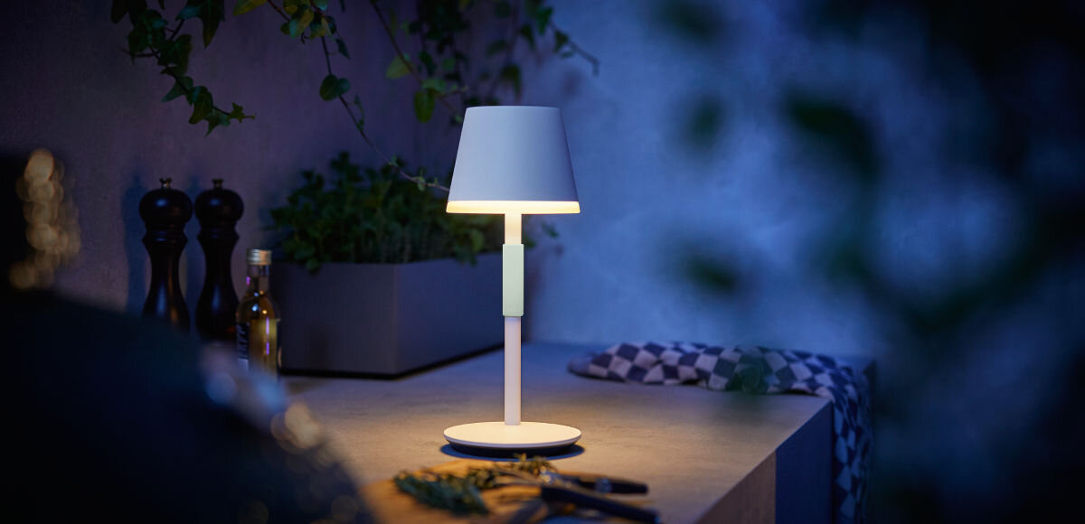 Lampa stołowa PHILIPS HUE 929003128401 Biały, silikon, uchwyt, konstrukcja, miejsce, lampa stoi na stoliku nocnym w pokoju w porze nocnej