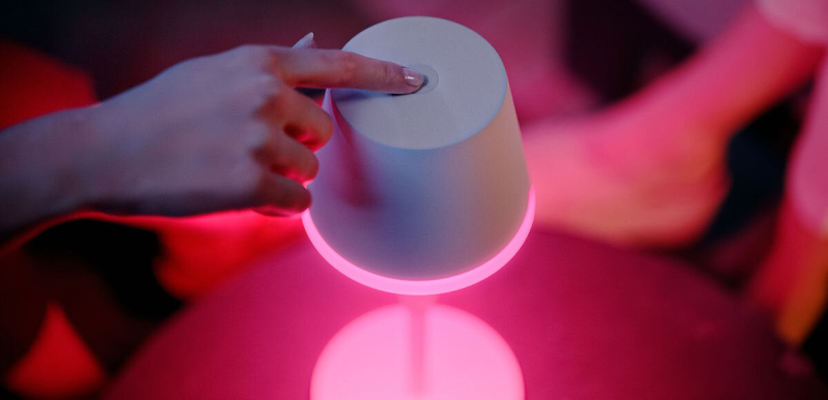 Lampa stołowa PHILIPS HUE 929003128401 Biały, włączanie, wyłączanie, sceny, światło, Dłoń przyciska lampkę od góry włączając ją