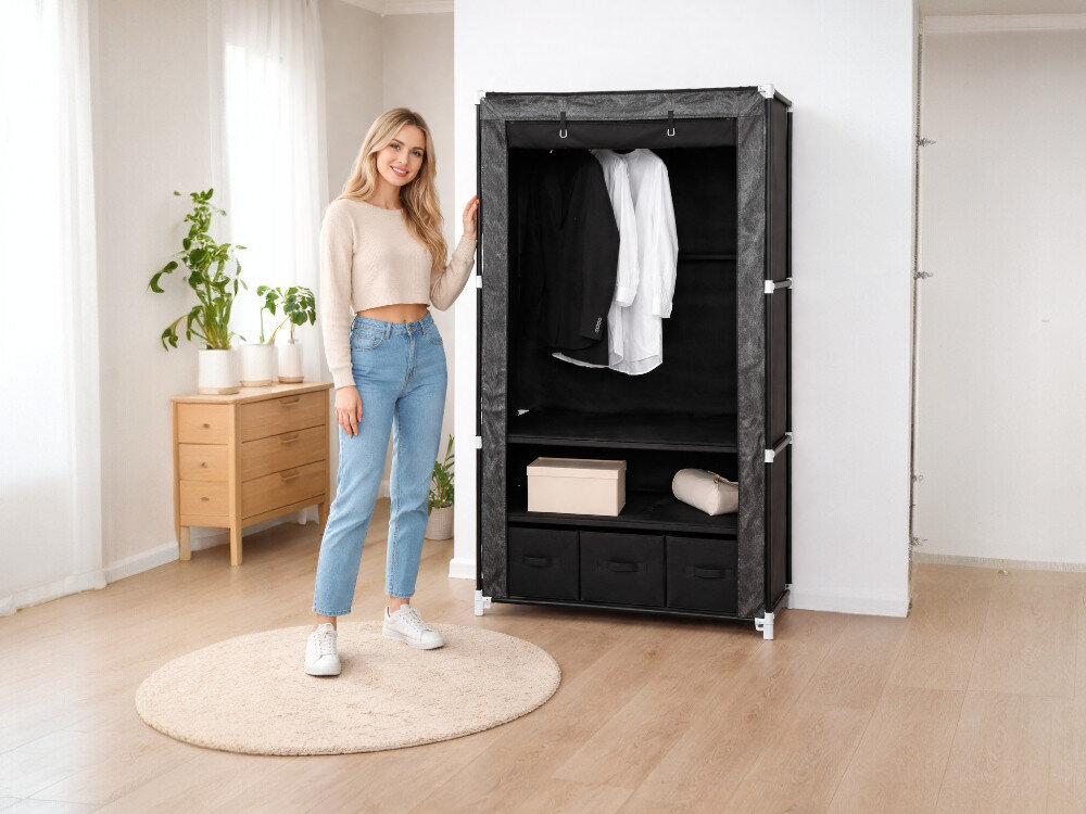 Szafa tekstylna SASKA GARDEN Ornament 45245 (88 x 50 x 160 cm) Czarny, szafa, tekstylna, mobilna, ubrania, kobieta stoi obok szafy w pokoju gościnnym
