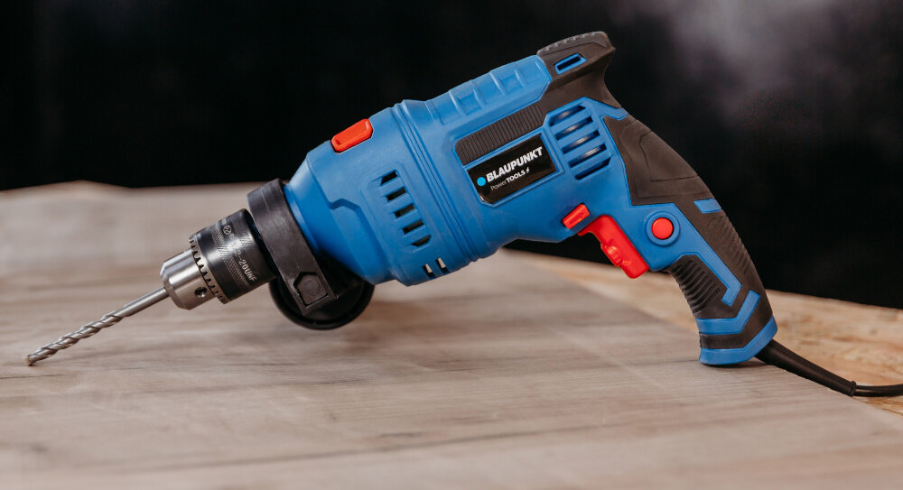 Wiertarka udarowa BLAUPUNKT ID8010 pomieszczenie drewniany blat ciemna ściana wkrętarka leży na blacie moc wiercenie wydajność uniwersalność wszechstronność