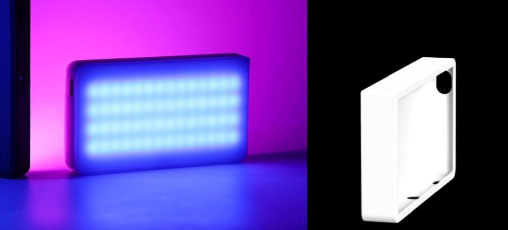 Kompaktowa lampa LED emituje niebieskie światło na tle różowej ściany. Obok znajduje się biały, prostokątny element z czarnym otworem w rogu.