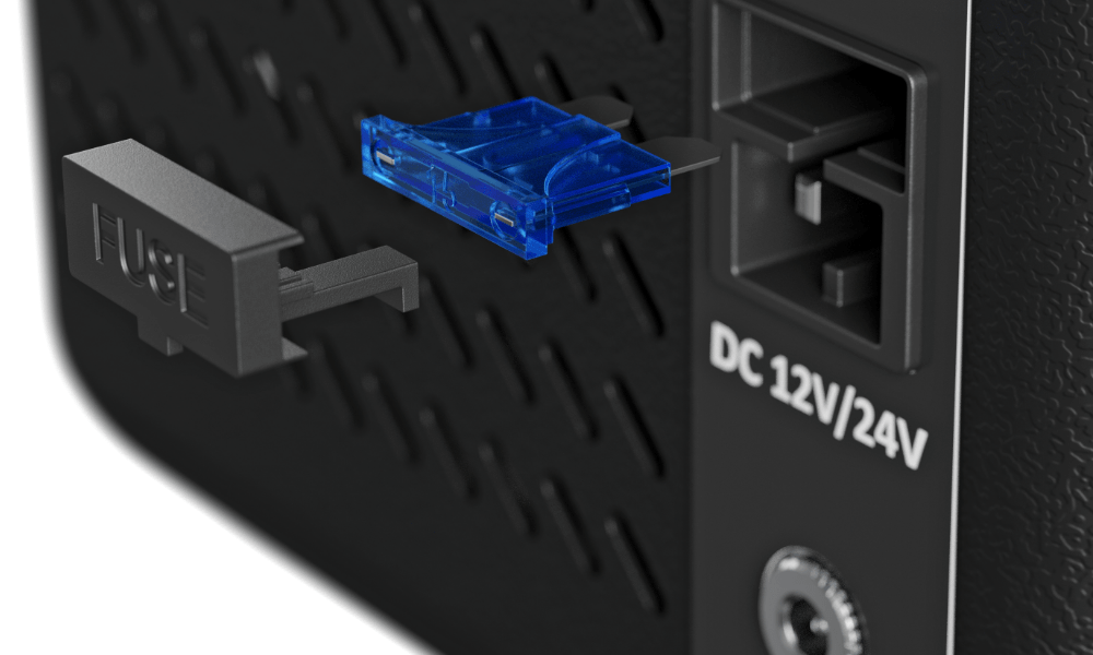 PRZENOŚNA LODÓWKA KOMPRESOROWA YOLCO ET8 CARBON Zbliżenie na port zasilania lodówki z oznaczeniem „DC 12V/24V” oraz gniazdo bezpiecznika opisane jako „FUSE”, z wyjmowanym elementem zabezpieczającym. Niebieski, półprzezroczysty bezpiecznik jest pokazany w trakcie montażu obok złącza port USB panel sterowania łatwa obsługa lodówka mobilna ergonomiczny uchwyt