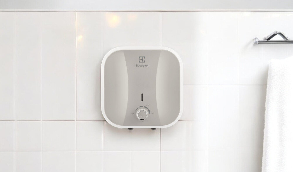 BOJLER ELEKTRYCZNY ELECTROLUX EWH10QOEEC lifestyle łazienka montaż na ścianie białe tło kompaktowy podgrzewacz wody łatwa instalacja ścienna pojemność 10 litrów wymiary 324 x 324 x 315 mm moc 2000 W temperatura do 65°C w 10 minut jakość trwałość Stalowy zbiornik powłoka ochronna odporny na korozję wygodna obsługa panel sterowania pokrętła 4 poziomy regulacji
