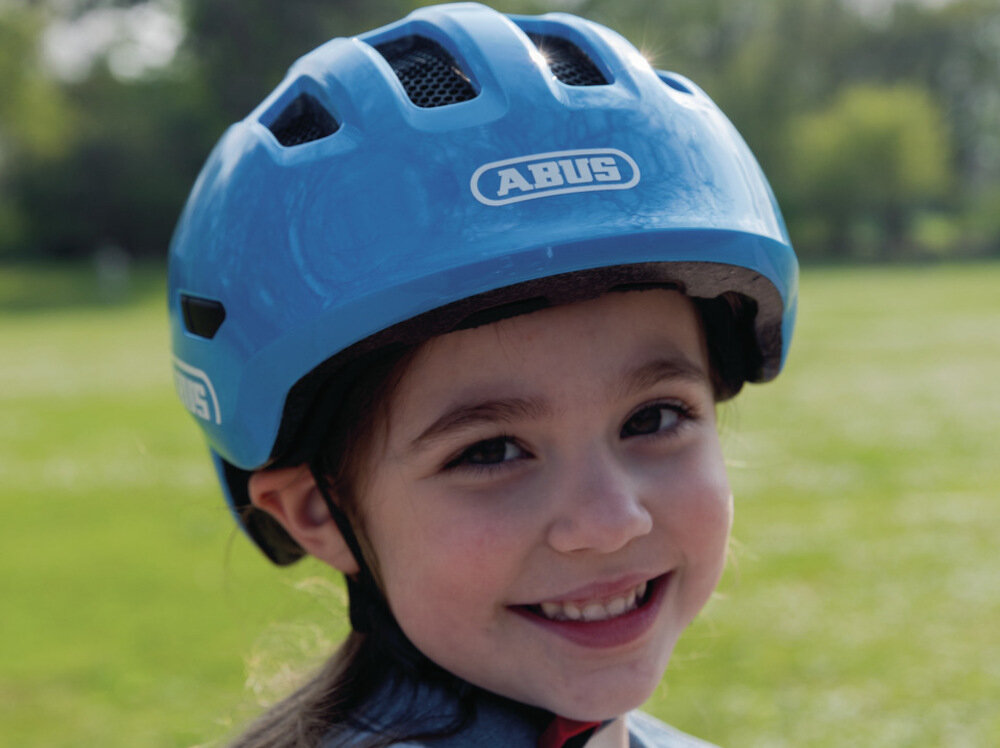 Kask rowerowy ABUS Smiley 3.0 LED Szaro-zielony dla Dzieci (rozmiar M) ochrona głowy dziecka rozciąga się na skronie i szyję gruba wkładka pod podbródek zabezpieczenie szczęki