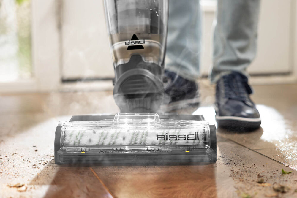 Płyn do odkurzaczy myjących BISSELL CrossWave Max 2765N/Pet Pro 2225N/X7 Plus Pet Pro 3400N / SpinWave 20522 1000 ml Odkurzacz parowy Bissell podczas czyszczenia podłogi drewnianej, widoczna gęsta para wodna wydobywająca się spod szczotki obrotowej.