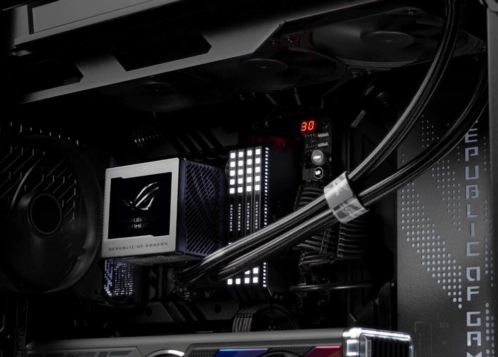 Chłodzenie wodne ASUS ROG Ryujin III 240 Wnętrze komputera z widocznym blokiem chłodzenia cieczą z logo 'Republic of Gamers', podświetlanymi modułami pamięci RAM i przewodami chłodzenia, opis