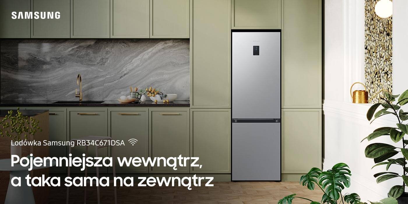 Wnętrze kuchni z lodówką w kolorze metalicznego grafitu, obok szafki i dekoracje. Tekst na obrazie: \'Lodówka Samsung RB34C671DSA Pojemniejsza wewnątrz, a taka sama na zewnątrz\'.