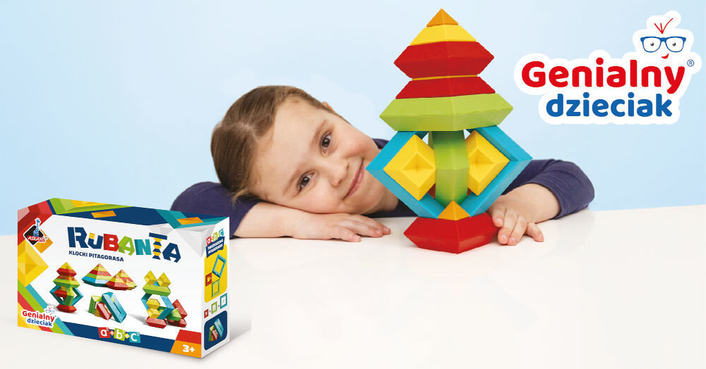 Uśmiechnięte dziecko przy białym stole z ułożoną wieżą z klocków pitagorejskich oraz pudełkiem klocków Rubanta 30 elementów.