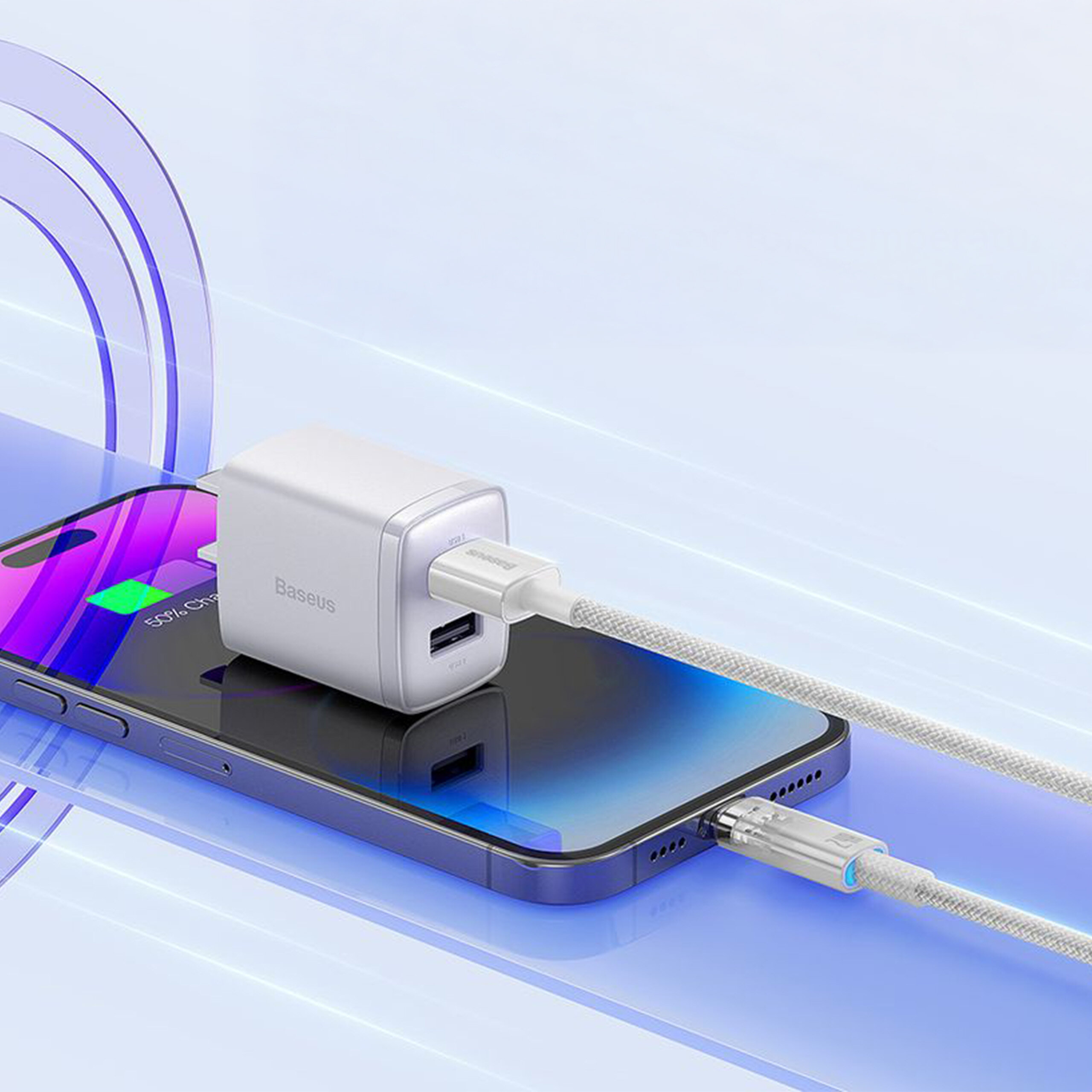 Na obrazie widać smartfon z podłączonym kablem do ładowania, na którym leży biały adapter z logo \'Baseus\'. Kabel jest podłączony do portu USB adaptera, a ekran telefonu pokazuje ikonę ładowania baterii.
