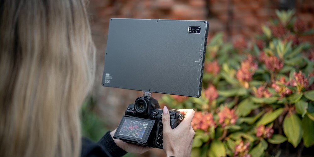 Wyświetlacz lampy LED Newell RGB-W Rangha Max XL zamontowana na aparacie trzymanym przez kobietę