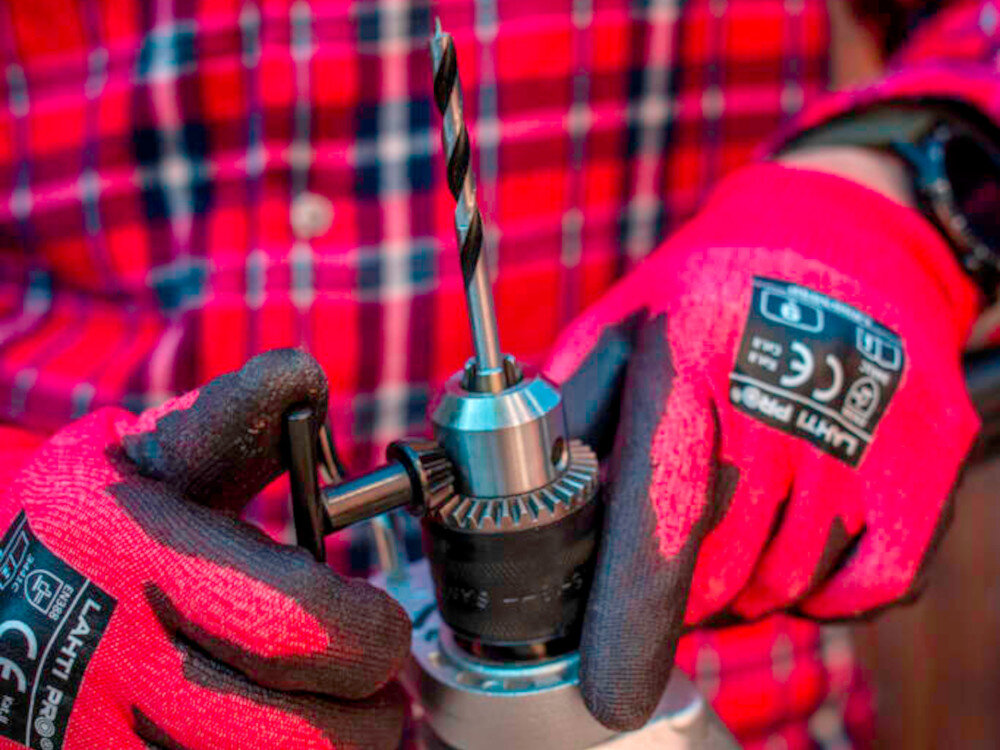 Wiertarka udarowa TRYTON TDW1050A pomieszczenie drewniany blat roboczy osoba trzyma wiertarkę w dłoniach zbliżenie na uchwyt wiertarski uchwyt z wieńcem zębatym pewnie trzyma wiertła w zakresie od 1,5 do 13 mm stabilne osadzenie narzędzia ogranicza drgania wiertła poprawia dokładność wykonywanych otworów zwiększa bezpieczeństwo pracy solidna konstrukcja przewód o długości 3 metrów swoboda ruchów wytrzymałość