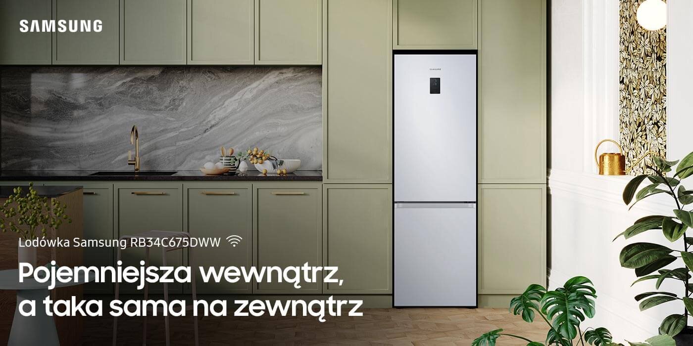 Biała lodówka Samsung RB34C675DWW stoi w eleganckiej kuchni z zielonymi szafkami i marmurowym blatem. Na obrazie widoczny jest tekst: \'Pojemniejsza wewnątrz, a taka sama na zewnątrz\'.