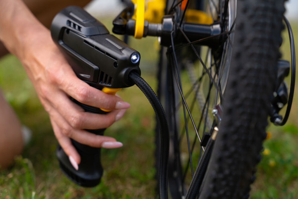 Pompka rowerowa BECOOL BC-PP2507C włączone oświetlenie led przewód podłączony do koła roweru