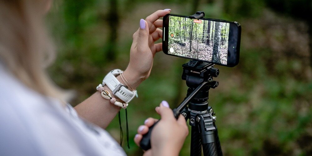 Kobieta nagrywająca las smartfonem zamocowanym na statywie Fotopro X-Aircross 3 Lite Video