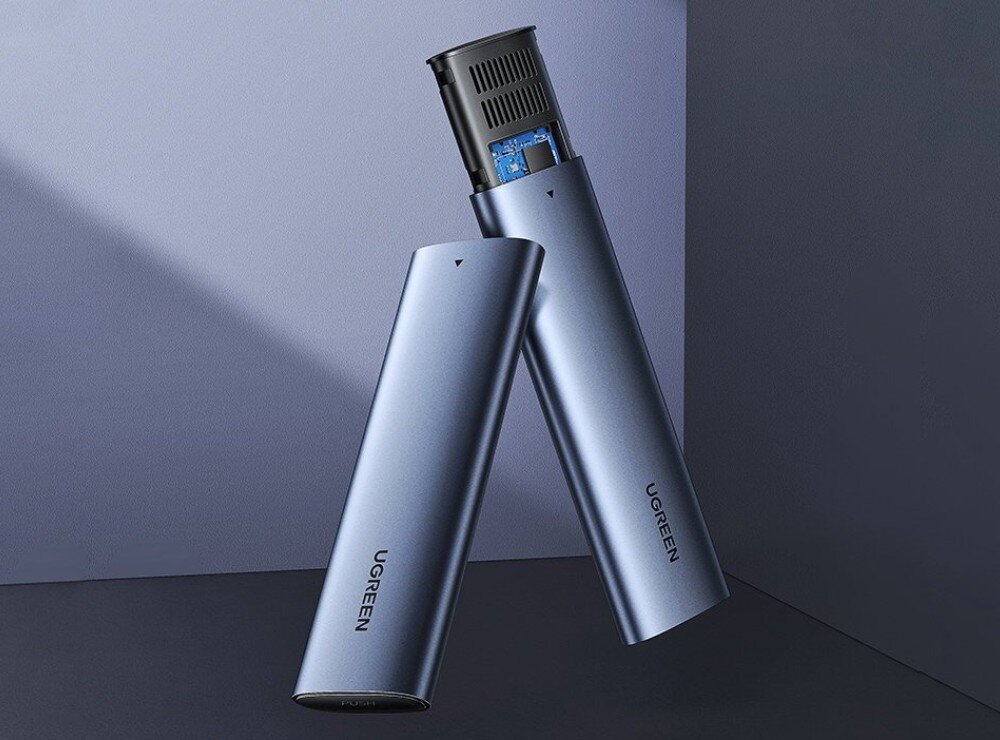 Obudowa dysku UGREEN CM400 10902 Srebrna obudowa na dysk zewnętrzny o podłużnym kształcie z wysuniętą górną częścią, która odsłania czarny element z otwieranymi otworami wentylacyjnymi i widocznym fragmentem niebieskiej płytki drukowanej