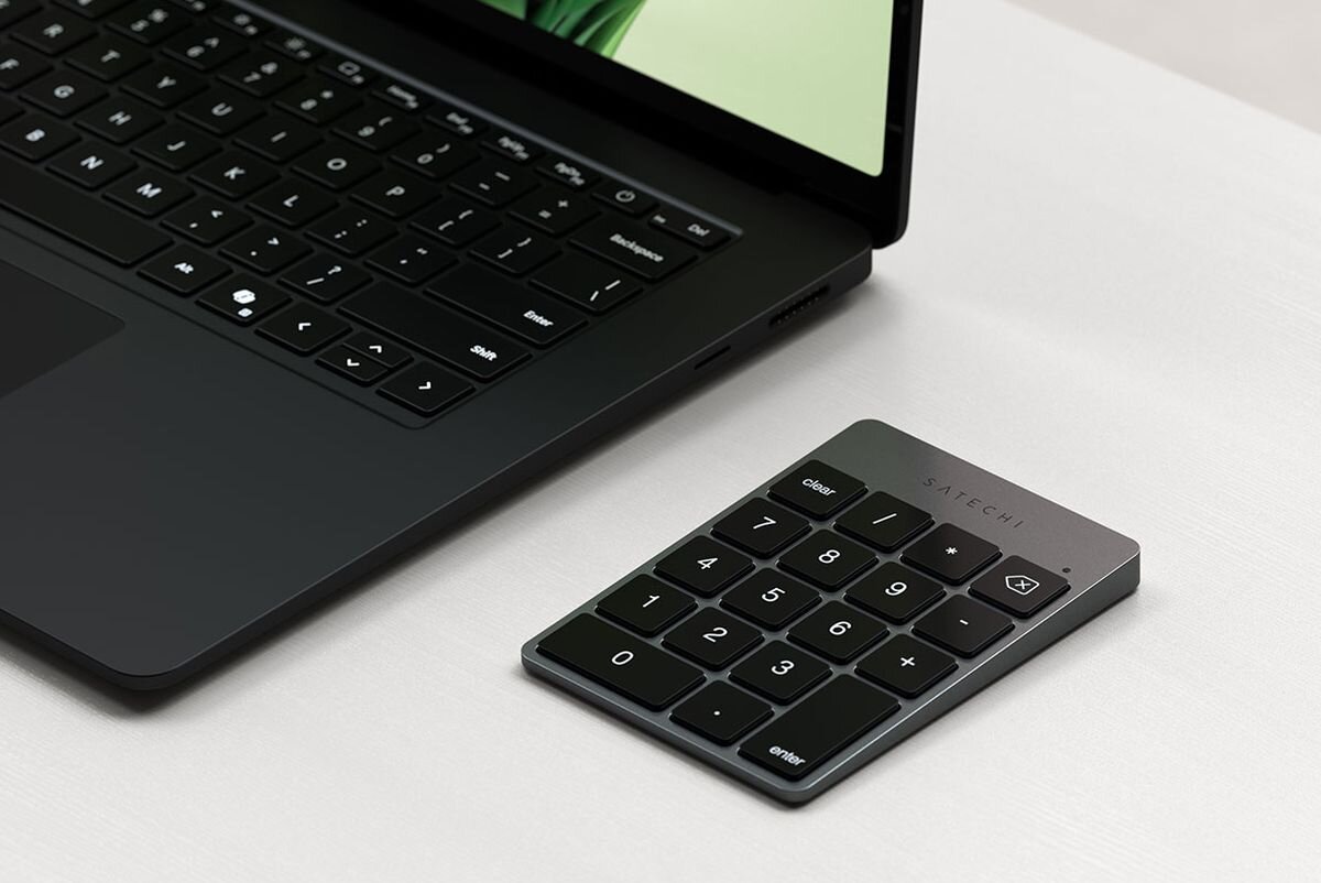 SATECHI Slim Wireless Niskoprofilowa konstrukcja kąt nachylenia klawiszy Aluminiowa obudowa - klawiatura na białym biurku obok laptopa