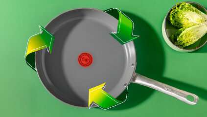Patelnia TEFAL Renew C4253813 objęta zielonymi strzałkami. Obok miska z sałatą.