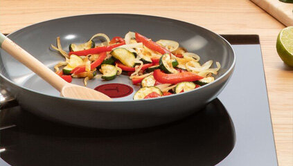 Patelnia TEFAL Renew C4253813 z jedzeniem na płycie indukcyjnej.