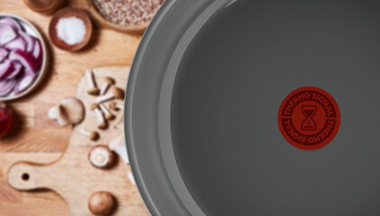 Patelnia TEFAL Renew C4253813, w tle różne składniki na blacie.