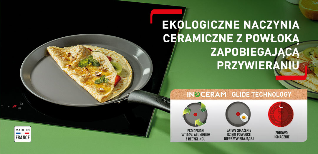 Patelnia TEFAL Renew C4253813 z jedzeniem na płycie kuchennej, obok talerz z naleśnikami. Apla z funkcjami patelni.