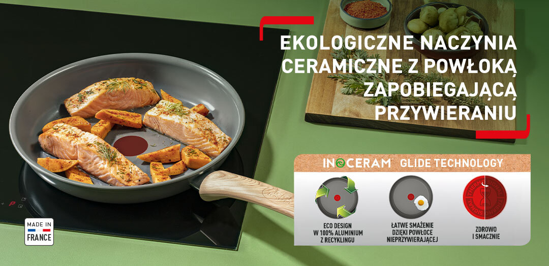 Patelnia TEFAL Renew C4250643 z jedzeniem na płycie kuchennej, obok drewniana deska z przyprawami. Apla z funkcjami patelni.