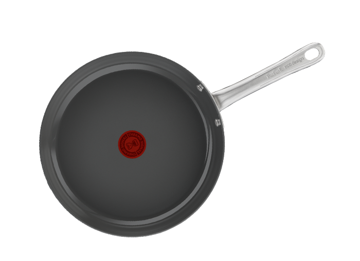 Na obrazie widoczna jest patelnia z ciemnym wnętrzem i metalowym uchwytem. Na środku patelni znajduje się czerwony okrągły symbol z tekstem \'THERMO-SPOT\'.