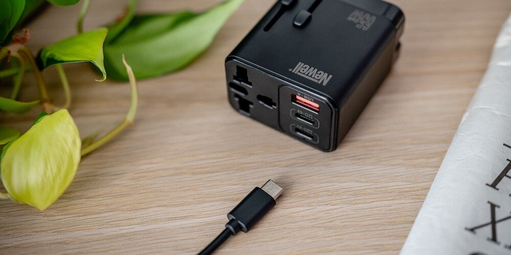Ładowarka Newell GaN travel adapter 65 W widoczne wtyczki USB-A USB-C oraz multi wtyczka