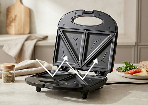 Otwarty Opiekacz do kanapek MOP-47 na blacie, trzałki odbijają się od powierzchni płyt.