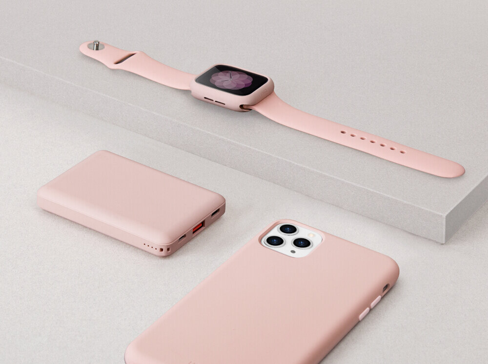 Na obrazie widoczne są trzy różowe urządzenia: smartwatch z różowym paskiem, smartfon z trzema aparatami oraz powerbank z dwoma portami USB. Wszystkie przedmioty leżą na jasnej powierzchni.