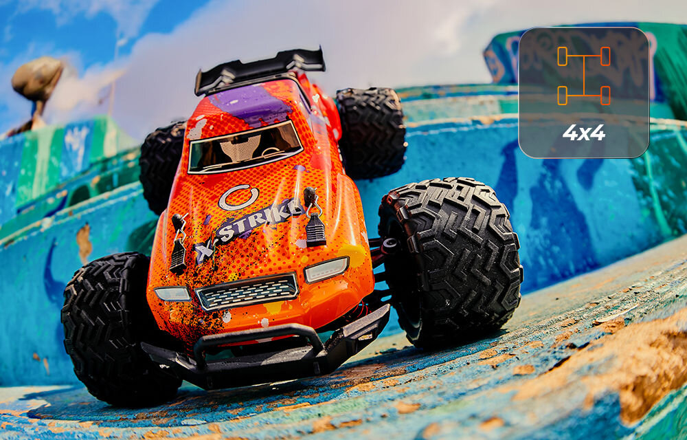 Samochód zdalnie sterowany OVERMAX X-Strike Pomarańczowo-czerwony samochód RC X-Strike podjeżdżający pod stary, niebieski, betonowy element. W prawym górnym rogu ikona schematu napędu 4x4.