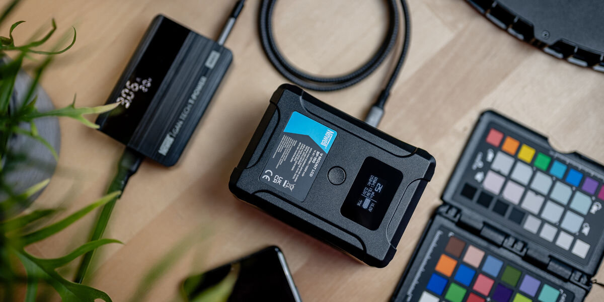 Akumulator NEWELL 14000 mAh do BP-190 LCD V-Mount, energia, oferuje, alternatywne, kompatybilność, na blacie leży akumulator wśród sprzętu elektronicznego