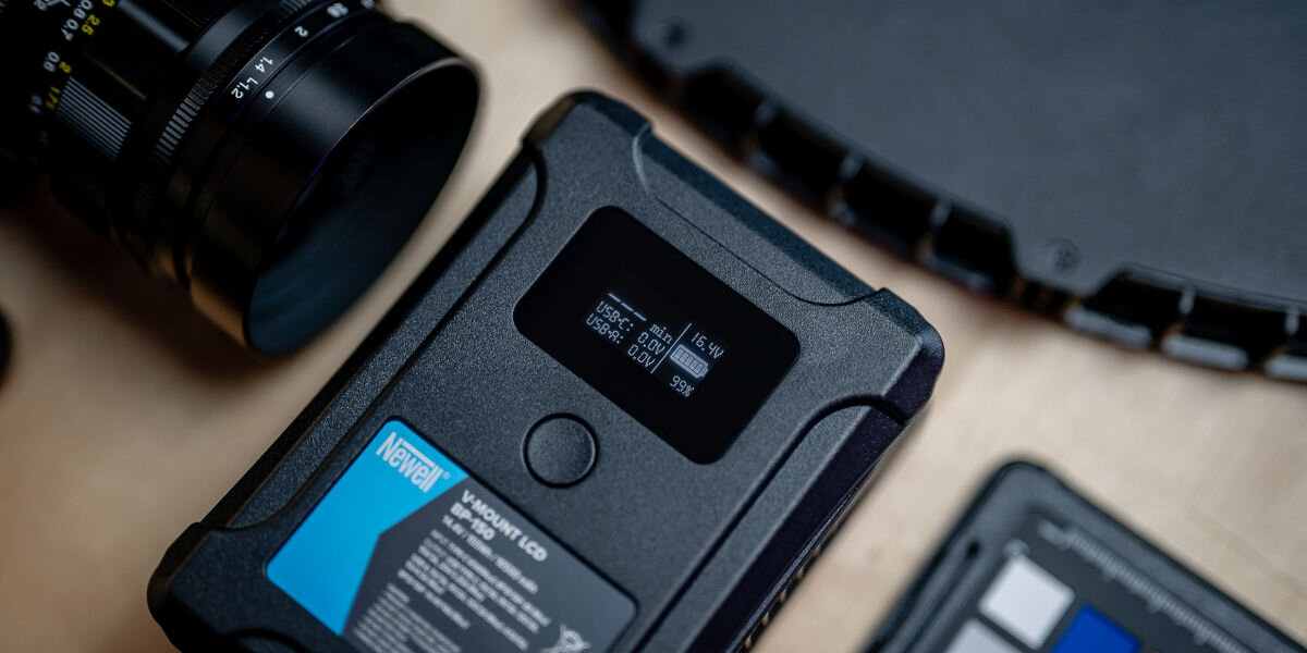 Akumulator NEWELL 10500 mAh do BP-150 LCD V-Mount, czytelny, lcd, wyświetlacz, monitorowanie, na blacie leży akumulator wsród elektroniki