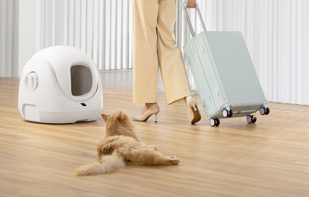 Inteligentna kuweta dla kota CATLINK Baymax biała kuweta rudy kot leży na podłodze kobieta idzie z walizką wygoda bezproblemowe doświadczenie pojemnik na odpady pojemność 7 litrów bez opróżniania nawet do 15 dni inteligentny system obrotowy przesiewa żwirek wymiana żwirku intuicyjna i błyskawiczna dostosowuje się do Twoich potrzeb