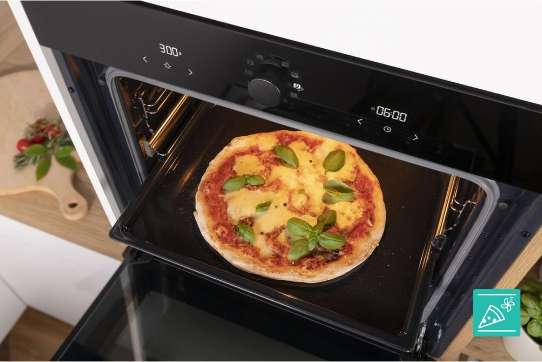 PIEKARNIK GORENJE BOS67371SYB Pizza piecze się na środkowym poziomie w czystym wnętrzu piekarnika z widocznym wentylatorem termoobiegu. Ujęcie podkreśla równomierne wypiekanie i chrupiący spód