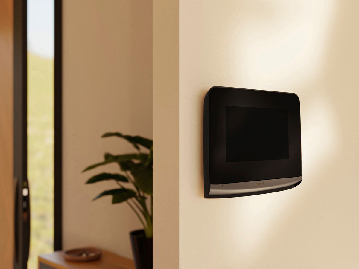 Monitor do wideomofonu SOMFY V500 2401458, przewody, montaż, okablowanie, uchwyt, monitor zamontowany do ściany, w tle pokój