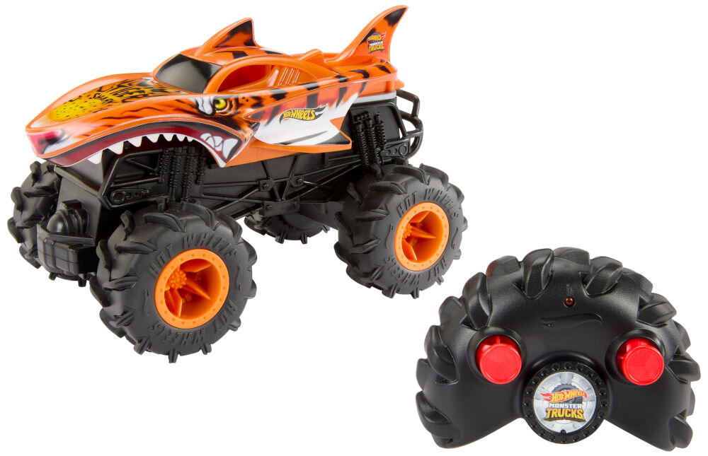 Samochód zdalnie sterowany Hot Wheels Tiger Shark HNV03 Zdjęcie zestawu: zdalnie sterowany samochód Hot Wheels Monster Truck Shark (pomarańczowo-czarny) stojący obok czarnego kontrolera (pilota) z czerwonymi przyciskami. Tło jest białe.