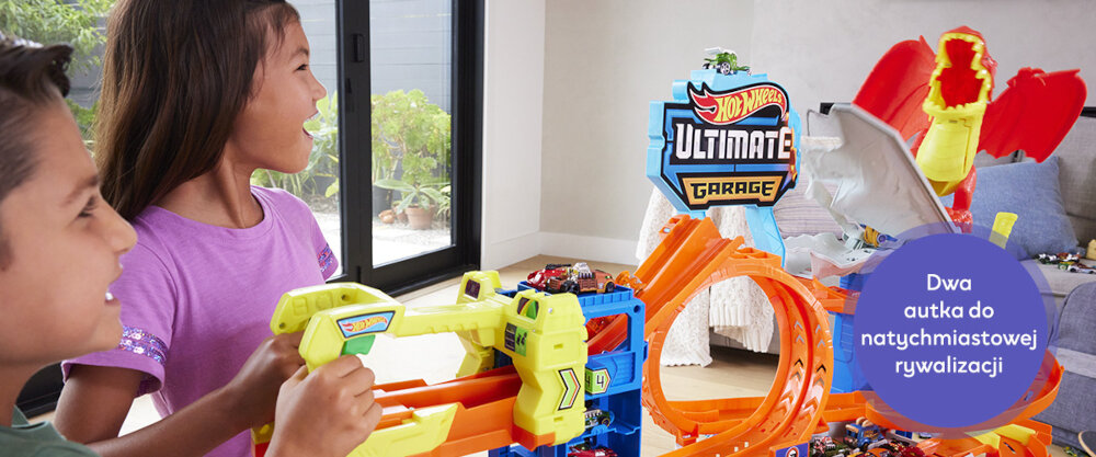 Dzieci bawiące się zestawem Hot Wheels City Atak Smoka, widoczny jest napis 'Dwa autka do natychmiastowej rywalizacji'.